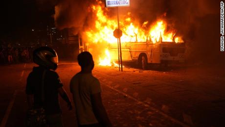 Sri Lanki oglądają płonący autobus podczas protestu przed domem prezydenta w Kolombo 1 kwietnia.