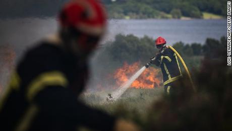 Strażacy spryskują wodą ogromny pożar w Monts d'Arey w Bretanii w północno-zachodniej Francji.