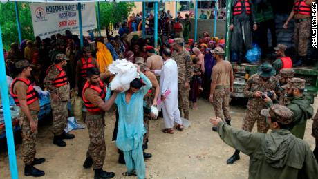 Siły armii rozdają żywność i zaopatrzenie przesiedleńcom w obozie pomocy humanitarnej w dystrykcie Jamshoro w południowym Pakistanie 24 sierpnia.