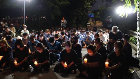 Niewielki tłum organizuje czuwanie przy świecach w Seulu 11 sierpnia, aby upamiętnić śmierć rodziny po zalaniu ich domu 8 sierpnia.