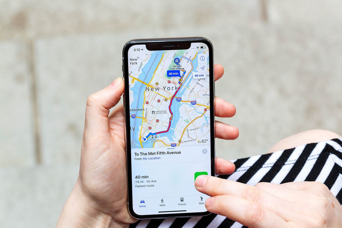 Osoba z iPhonem pokazująca trasę do miejsca w Nowym Jorku w Mapach Apple.
