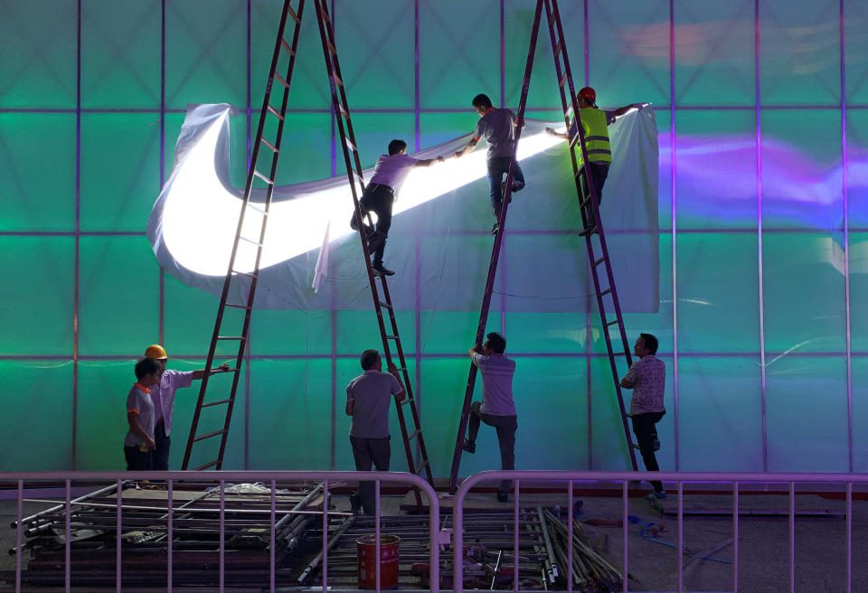 Pracownicy instalują lampę z logo Nike przed Wukesong Arena w Pekinie, Chiny, 28 sierpnia 2019 r. Zdjęcie zrobione 28 sierpnia 2019 r. REUTERS / Tingshu Wang