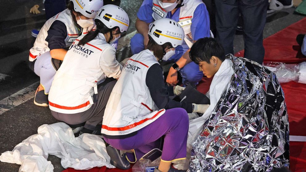 Zdjęcie: Mężczyzna otrzymuje pomoc medyczną od członków zespołu ratowniczego na miejscu, w którym kilkadziesiąt osób zostało rannych w panice podczas festiwalu Halloween w Seulu w Korei Południowej, 30 października 2022 r. 