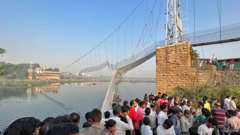 Ludzie zbierają się jako ratownicy szukający ocalałych po zawaleniu się mostu wiszącego w Morbi w zachodnim stanie Gujarat w Indiach, 31 października 2022 r. 