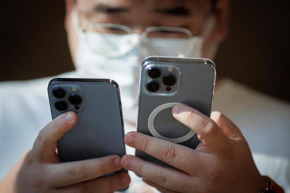 Mężczyzna ogląda iPhone'y w Apple Store, gdy nowe modele iPhone'a 14 firmy Apple Inc trafiają do sprzedaży w Pekinie, Chiny, 16 września 2022 r. REUTERS / Thomas Peter